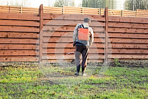 Man sprays grass with herbicide of a knapsack sprayer