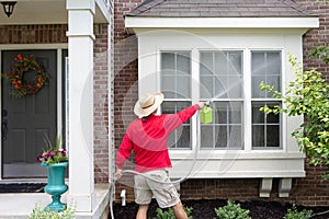 Man spring cleaning the exterior of his house