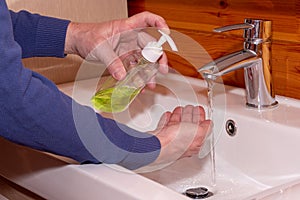A man sprinkles soap on his hands to wash them. Washes hands with soap at home in the sink. Hand hygiene versus coronavirus