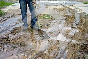 Man with spud on the muddy road photo