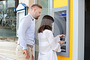 Man Spying For PIN Code While Woman Using An ATM