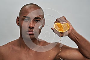 Man squashing an orange in his fist