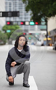 Man squatting in the street