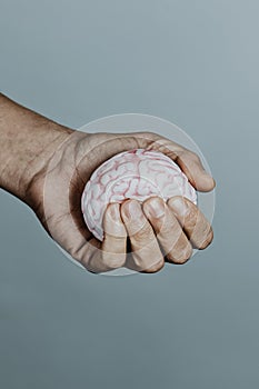 man squeezes a fake brain