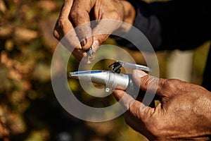 A man squeezes grapes into a refractometer for measurement