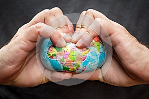 Man squeezing a globe, symbolic of flat earth, concept of conspiracy theory photo