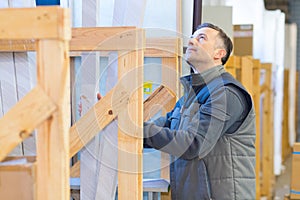 Man stacking materials in wooden racking
