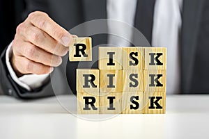 Man stacking wooden risk blocks