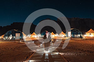 A man stading in front of martian dome tents in Wadi Rum Desert, Jordan