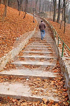 Man on stairs covered with leaves