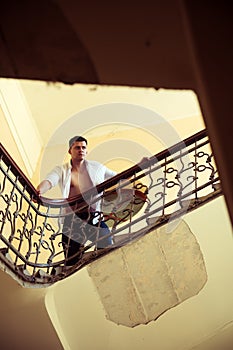 Man stand high on staircase. Businessman climb stairs. macho in open shirt with bare torso on stairway. Success in