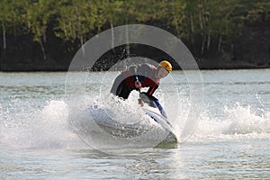 A man stand on the jet ski.