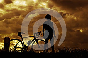 Man stand on Mountain bike silhouette in sunrise