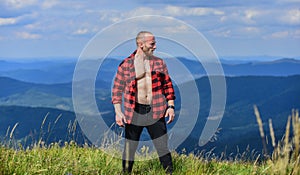 Man stand top mountain landscape background. Athlete guy relax mountains. Hiker muscular torso reach mountain peak