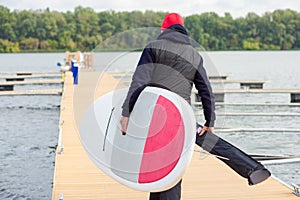 Man with stand up paddle board going to surf