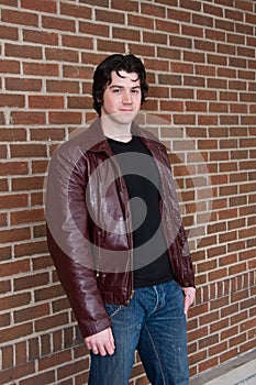 Man standing against a brick wall