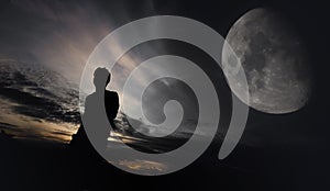 Man standing against moon in the background at night