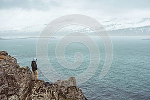 A Man standing alone on cliff in rainy day in Iceland