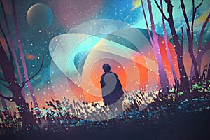 Man standing alone in forest with fictional planets background