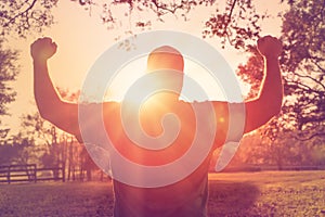 Man standing with arms raised in victory gesture photo