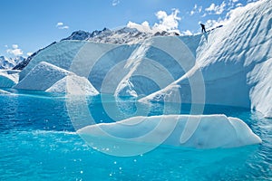 Man standing atop a large cliff over a deep blue pool on the Matanuska Glacier in Alaska