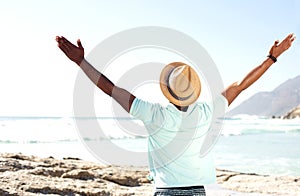 Man standing at beach with his hands wide open