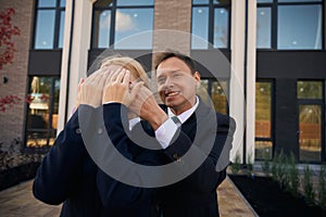 Man standing behind woman and closing her eyes with hands