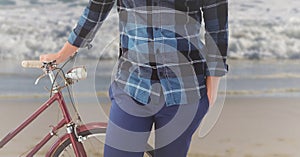 Man standing with bicycle on the beach