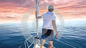 Man standing at the bow of a ship. Yachting, vacation and freedom concept