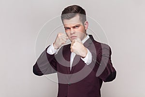Man standing with boxing fists and ready to attack or defence, looking with angry face.