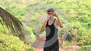 man standing in a boxing stance against the backdrop of nature