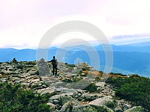 A man standing by cairn marker on Mt. Washington