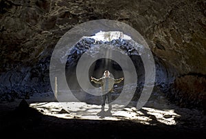 Man Standing In Cave Sunbeams