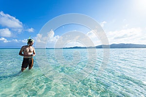 Man standing in clear tropical beach water, Okinawa, Japan