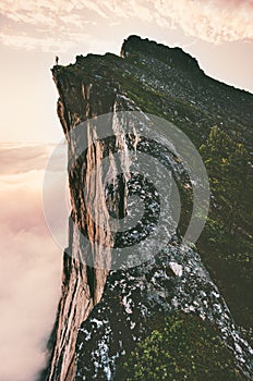 Man standing on cliff edge mountain ridge