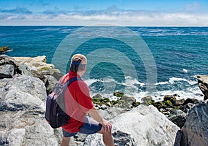 Hiker man relaxing by the Pacific ocean in California. photo