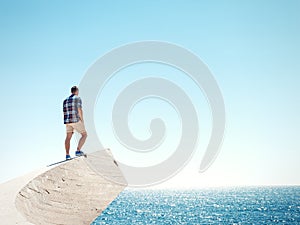 Man standing on a cliff and sea