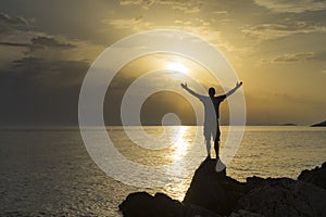 Man standing close the Adriatic Sea in Croatia at sunset holding arms out