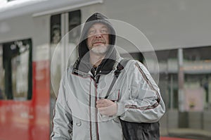 A man standing confidently in front of a train, ready to embark on his journey. photo