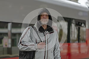 A man standing confidently in front of a train, ready to embark on his journey. photo