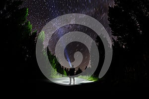 Man Standing in Dark Stars with Flashlight Forest Night Sky