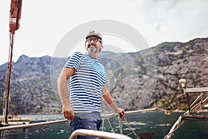 Man standing on the deck of his boat on a sunny afternoon