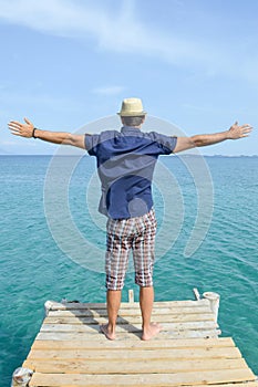 Man standing on a dock at seaside