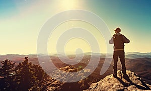 Man standing at the edge of a cliff overlooking the mountains