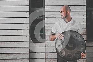 Man is standing eith hangdrum