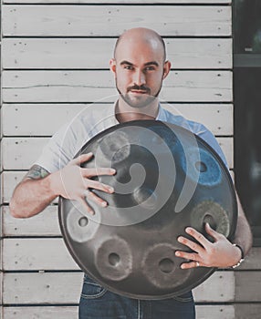 Man is standing eith hangdrum