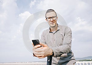 Man standing with an electric scooter and smartphone.