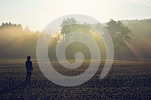 Man standing in the fog at sunrise