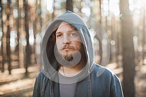 Man is standing in the forest and just relaxing dressed like homies in dark blue goodie