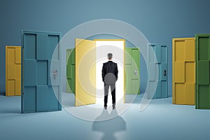 Man standing in front of abstract colorful puzzle door in interior. Future, choice, success, direction, opportunity and solution